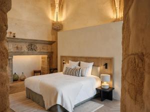 a bedroom with a large white bed and a fireplace at Les Hauts de Sancerre in Sancerre