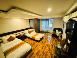 a hotel room with two beds and a television at De Hotel Veda Pvt Ltd in Thapathali
