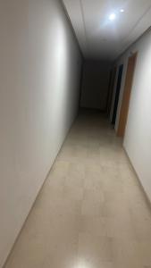 an empty hallway with white walls and a tile floor at Splus1 in Nabeul