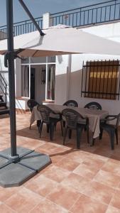 a patio with a table and chairs and an umbrella at Casa Benzambra in Cádiar