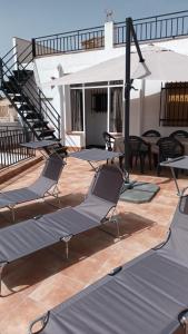 a deck with chairs and tables on a house at Casa Benzambra in Cádiar