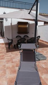 a trampoline in a patio with a table and chairs at Casa Benzambra in Cádiar