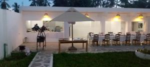 a patio with a table and an umbrella at Lilo House in Watamu