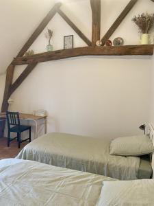 a bedroom with two beds and a desk with a chair at Le Logis du pic vert in Saint-Mathurin +27 photos