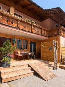 a house with a wooden deck and a table at Appartements Baumanngut in Wagrain