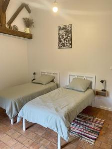 two beds sitting next to each other in a room at Le Logis du pic vert in Saint-Mathurin