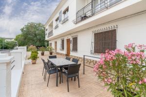 a patio with a table and chairs and pink flowers at Raízes 22 - Apartamento 6 in Puebla de Don Fadrique