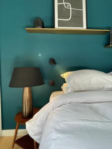 a blue bedroom with a bed and a lamp at Ostan Hôtel Boutique in Roquebillière