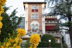 a building with yellow flowers in front of it at VILLA UGO b & b in Salsomaggiore Terme