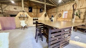 a large room with a wooden table in a barn at Refúgio em Gramado | cabana c/ hidromassagem in Gramado