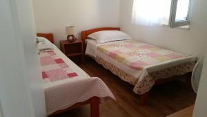 a small bedroom with two beds and a window at Hilly house - Vis in Vis