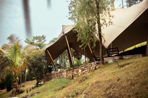 a tent on top of a hill with trees at Kibuye House in Kibuye +23 photos