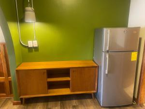 a kitchen with a refrigerator and a green wall at Cavi Rooms 511 in Cuenca