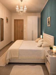 a bedroom with a large bed and a chandelier at B&B Jasmine Park Ormea in Ormea