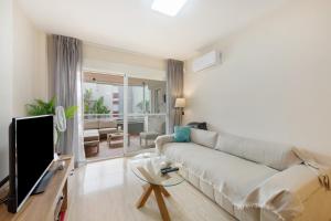 a living room with a couch and a tv at Apartamento de lujo Almerimar in Almerimar
