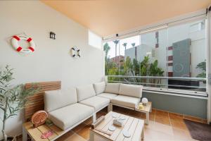 a living room with a white couch and a large window at Apartamento de lujo Almerimar in Almerimar