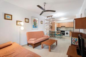 a living room with a couch and a chair and a kitchen at Residencial La Gomera in Puertito de Güímar