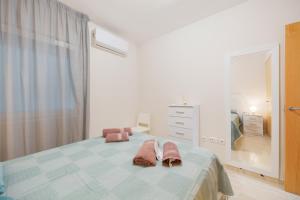 a bedroom with a bed with pink towels on it at Apartamento de lujo Almerimar in Almerimar +22 photos