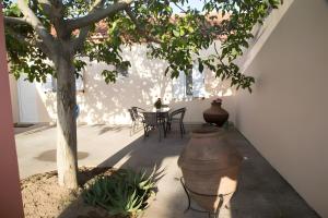 a patio with a tree and a table and chairs at Evoia Village House in Neokhórion