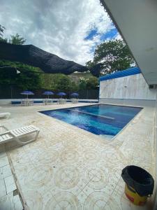 a swimming pool with chairs and umbrellas on a patio at Villa Tania in Melgar