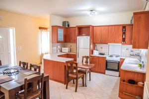a kitchen with wooden cabinets and a table and a dining room at Evoia Village House in Neokhórion