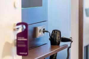 a phone sitting on a table next to a door at Premier Inn Köln City Mediapark in Cologne