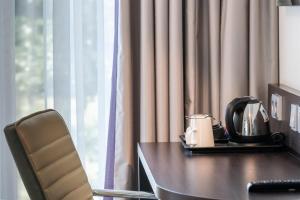 a hotel room with a table with a tea kettle on it at Premier Inn Köln City Mediapark in Cologne +45 photos