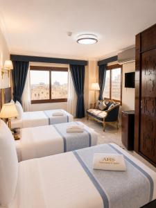a hotel room with three beds and a couch at El Amin Hotel & Suites - Downtown Cairo in Cairo +47 photos