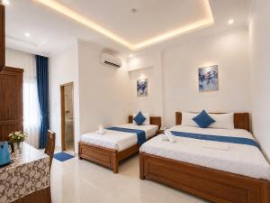 a hotel room with two beds and a table at Phuong Thuy Hotel in Can Tho +21 photos