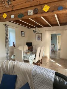a dining room and living room with a table and chairs at GITE EQUESTRE DE LA LANDE in Bréhal