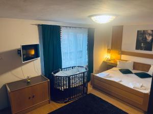 a bedroom with a bed and a crib in it at Villa Bran Legend in Bran