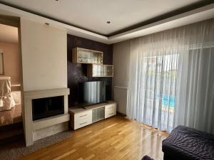 a living room with a fireplace and a television at Vila Giulietta in Kaštela