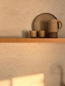 a shelf with two cups and a mug on it at KITO suites in Kitriaí