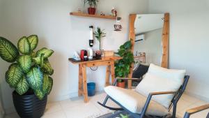 a room with a desk and two chairs and a plant at جناح فاخر بإطلالة على البحيرة وجاكوزي خاص in Al Khobar