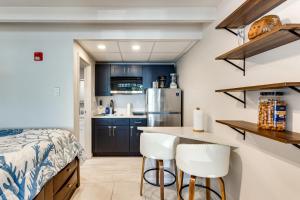 a kitchen with a bed and two white bar stools at Dolphin & Manatee Cove Condo: Beach Access + More! in Gulf City