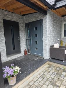 a blue door on a brick house with flowers at 1 sleeping room in Fagernes +1 photo