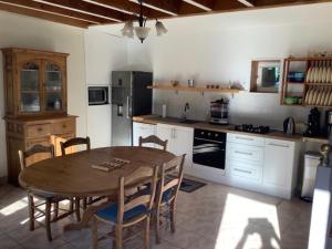 a kitchen with a wooden table and a table and chairs at GITE EQUESTRE DE LA LANDE in Bréhal