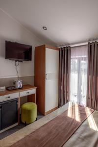 a hotel room with a bed and a desk and a tv at Mountain View Boutique Hotel in Almaty