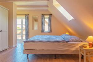 ein Schlafzimmer mit einem Bett mit blauen Kissen in der Unterkunft Ferienwohnung Koppelblick III - Boldevitzer Rügenkaten in Parchtitz