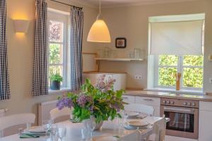 eine Küche mit einem Tisch, auf dem eine Blumenvase steht in der Unterkunft Ferienwohnung Koppelblick III - Boldevitzer Rügenkaten in Parchtitz