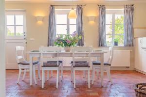 ein Esszimmer mit einem weißen Tisch und Stühlen in der Unterkunft Ferienwohnung Koppelblick III - Boldevitzer Rügenkaten in Parchtitz