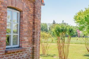 ein Backsteingebäude mit einem Fenster und Bäumen auf einem Feld in der Unterkunft Ferienwohnung Koppelblick III - Boldevitzer Rügenkaten in Parchtitz + 8 Fotos