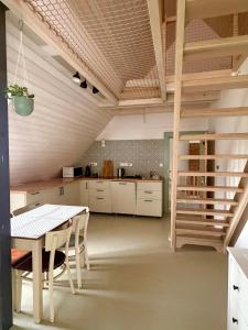 a dining room with a table and a kitchen at Domek Kavalírek in Lipova Lazne