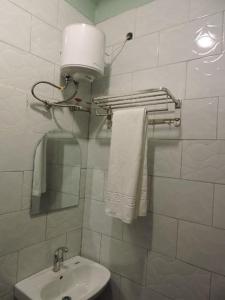 a bathroom with a sink and a toilet and a mirror at EL ROi KADOSHI MOTEL in Kyenjojo +14 photos