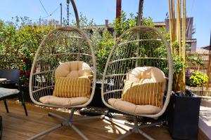 two wicker chairs sitting on top of a patio at Hotel Caravita in Rome