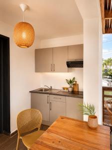 a kitchen with a wooden table and a dining room at Cote Plage in La Saline les Bains