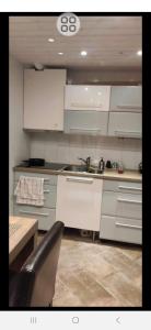 a kitchen with white cabinets and a sink at 1 sleeping room in Fagernes