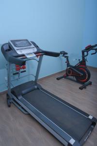 a treadmill and a bike on a wooden floor at EL ROi KADOSHI MOTEL in Kyenjojo