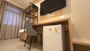 a room with a refrigerator and a desk with a tv at Di Garda Hotel in Encarnación