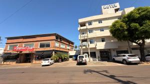 a street with cars parked in front of a building at Di Garda Hotel in Encarnación